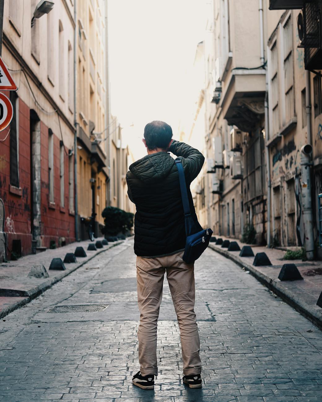 man photographing paved city street