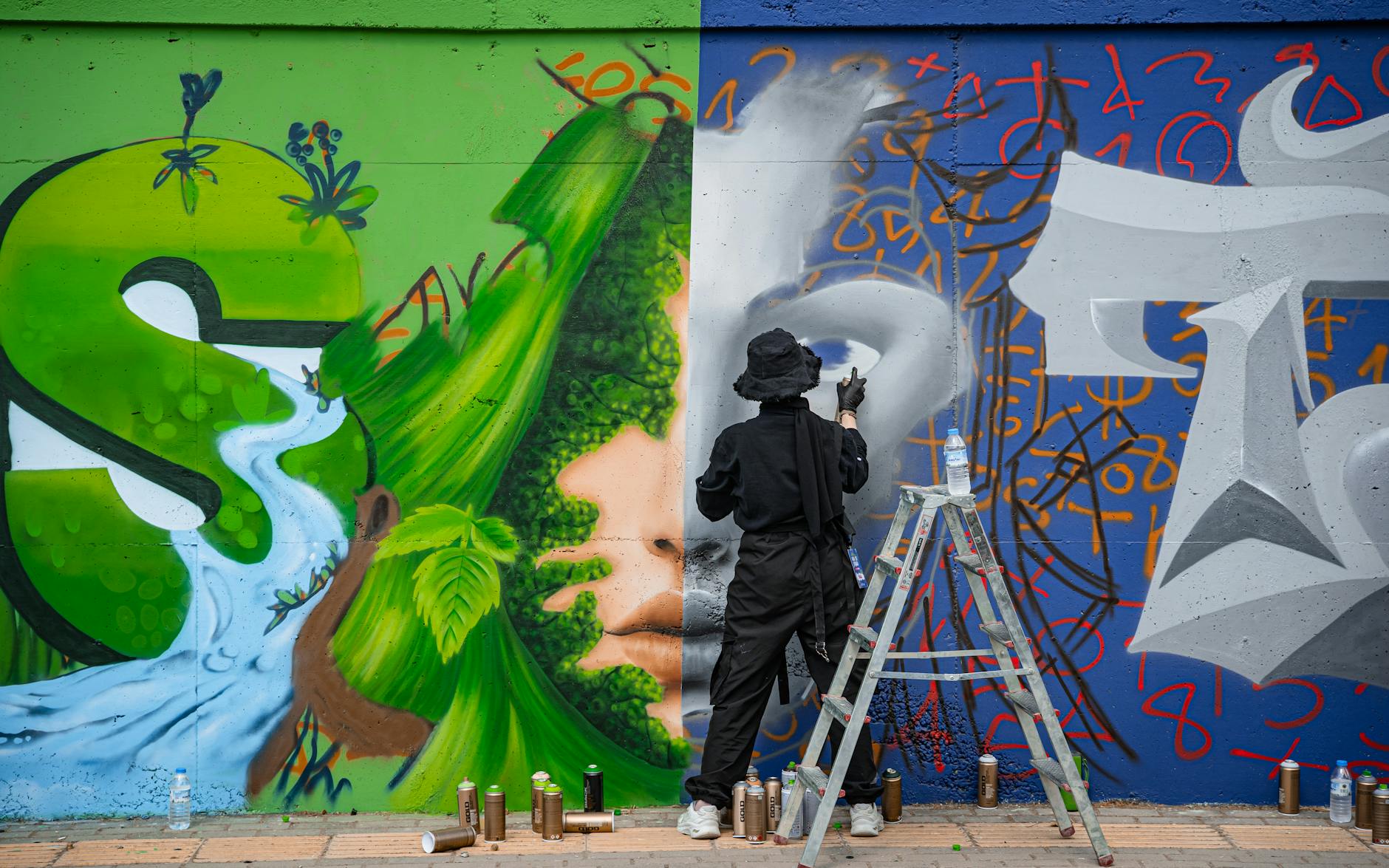artist creating vibrant wall mural graffiti