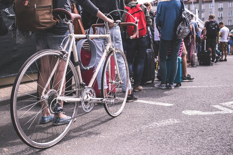 A diverse group of adults lined up in a city street, showcasing urban life.