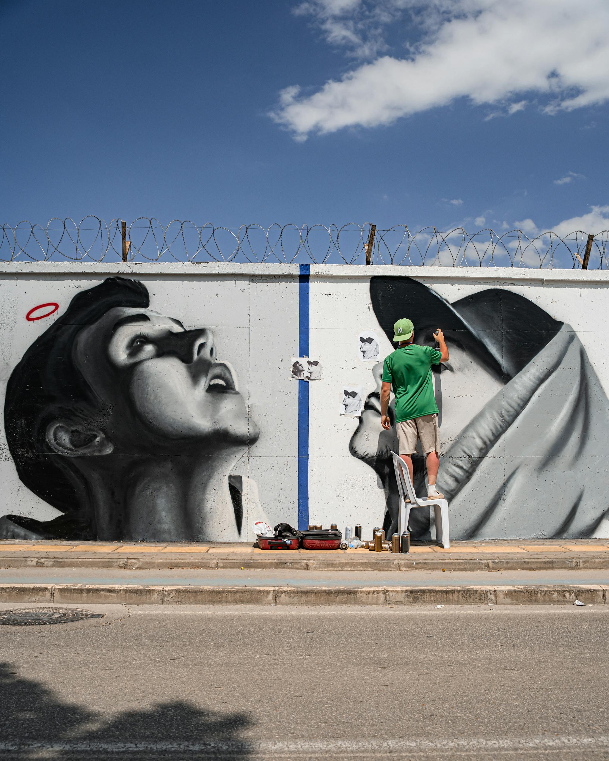 Vibrant street art depicting cartoonish faces and fish on an urban wall.